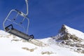 Chair lift in the foreground against the background of snow-capped mountains and blue sky.Austrian Alps in winter Royalty Free Stock Photo