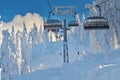 Chair lift in Poiana Brasov ski resort, Skiers and snowboarders enjoy the ski slopes in Poiana Brasov winter resort whit forest