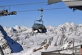 Chair lift in ski resort with snowcapped mountain peaks in the background Royalty Free Stock Photo