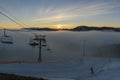 Chair Lift for Skiers Moving on the Mountain Top at Sunset time and Foggy Day in Bukovel Ski Resort, Carpathians Royalty Free Stock Photo