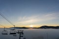 Chair Lift for Skiers Moving on the Mountain Top at Sunset time and Foggy Day in Bukovel Ski Resort, Carpathians Royalty Free Stock Photo