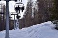 Chair lifts in Italian ski resort Sauze D\'Oulx rising through woodland