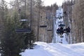 Chair lifts in Italian ski resort Sauze D\'Oulx rising through woodland