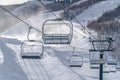 Chair lifts over snowy mountain and snow cannons