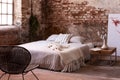 industrail bedroom interior with flowers on wooden table and red brick wall. Real photo Royalty Free Stock Photo