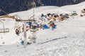 Chair ski lift on the background of a small mountain village with cafe and rental of skis and snowboards