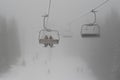 Chair Ski Lift With Skiers Silhouettes In Deep Mist