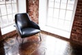 Chair stands near a window on the brick wall background in the w Royalty Free Stock Photo