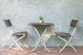 Chair and table on wood patio and loft wall in background