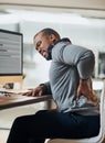 This chair is tarting to hurt my back now. a young businessman suffering from a backache while working at his desk in Royalty Free Stock Photo