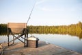 A Chair on a Wooden Dock Looking Out on a Lake in Summer with Fishing Equipment Royalty Free Stock Photo