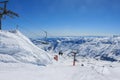 Chairlift on the background of snow-capped peaks and blue sky. The concept of active winter recreation Royalty Free Stock Photo