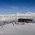 Chairlift at Italian ski area of Pila on freshly groomed snow covered Alps above clouds - winter sports concept Royalty Free Stock Photo