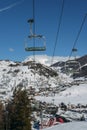 Chairlift at Italian ski area on snow covered Alps and pine trees during the winter, winter sports concept Royalty Free Stock Photo