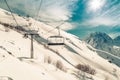 Chairlift lifts skiers and snowboarders to the top of the mountain near the village of Dombai, Russia in a winter sunny day Royalty Free Stock Photo