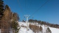 Chairlift over a snow-covered mountainside against a blue sky. Royalty Free Stock Photo