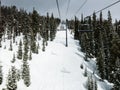 Chairlift on a slope of a ski resort under gray sky