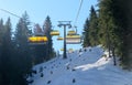 chairlift with snow and trees underneath the blue sunny sky Royalty Free Stock Photo