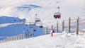 Chairlift and wooden fence at Cota 2000, Sinaia ski domain, Romania, on a sunny Winter day