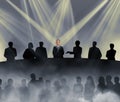 The chairman of the board is bathed in light and surrouned by his minions Royalty Free Stock Photo