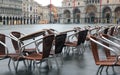 Chairs of the alfresco cafe in Saint Mark Square during the high tide in Venice in Italy Royalty Free Stock Photo