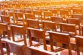 Chairs in the church in the prayer hall, wooden brown armchairs in rows behind