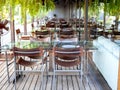 Chairs and dining glass tables on wooden floor, restaurant interior