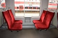 Chairs in an electric train with red velor upholstery. The interior of the train car. Royalty Free Stock Photo