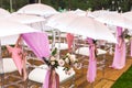 Chairs, flowers and umbrellas at an outdoor ceremony