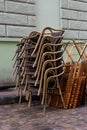 Chairs folded. stainless steel polished tables in front of a cafe wet from rain and dew. the season of outdoor terraces ends Royalty Free Stock Photo