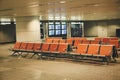 Chairs for passengers in the empty hall of Guangzhou Airport. The sign says `gate locationÃÂ» and the flight schedule China. Royalty Free Stock Photo