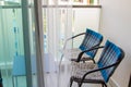 Chairs and table in the balcony behind panoramic window with transparent tulle