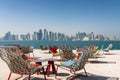 Chairs and tables in front of the skyline of Doha, Qatar Royalty Free Stock Photo