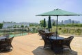 Chairs,tables and sunshades on planked roof terrace of uptown bu Royalty Free Stock Photo