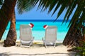 Chairs on tropical beach and Santa Claus red christmas hat Royalty Free Stock Photo