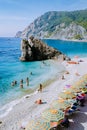 Chairs and umbrellas fill the spiaggia di fegina beach , the wide sandy beach village of Monterosso Italy, part of the