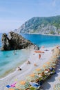 Chairs and umbrellas fill the spiaggia di fegina beach , the wide sandy beach village of Monterosso Italy, part of the