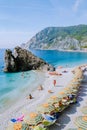 Chairs and umbrellas fill the spiaggia di fegina beach , the wide sandy beach village of Monterosso Italy, part of the