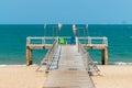 Chairs on a wooden platform with wicker lanterns by the sea