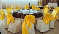 Chairs with yellow cloth and table for guests served for wedding. Royalty Free Stock Photo