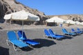 Chaise lounges on black beach of Santorini island, Greece Royalty Free Stock Photo