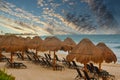 Chaise Lounges Under Straw Thatched Umbrellas on a Beach Royalty Free Stock Photo