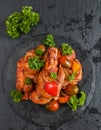 Chakhokhbili, chicken stew, cooked with tomatoes, bell peppers, spices and herbs. Black stone background, top view Royalty Free Stock Photo