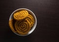 A top view of bowl full of crispy fried chaklees in a bowl.