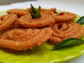 Chakli in a Green Plate on White Background. Indian Snack Chakli or chakali made from deep frying portions of a lentil