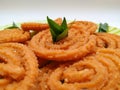 Chakli in a Green Plate on White Background. Indian Snack Chakli or chakali made from deep frying portions of a lentil