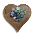 Chakra Crystal tumbled stones on wooden heart plaque Royalty Free Stock Photo