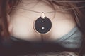 Chakra medallion hanging on the woman`s Breasts