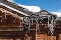 Chalet close-up: gutter with ice and turned off christmas lights Royalty Free Stock Photo