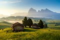 Chalets at Seiser Alm, high altitude meadow with Langkofel mountain in background at sunrise, Dolomites, Italy